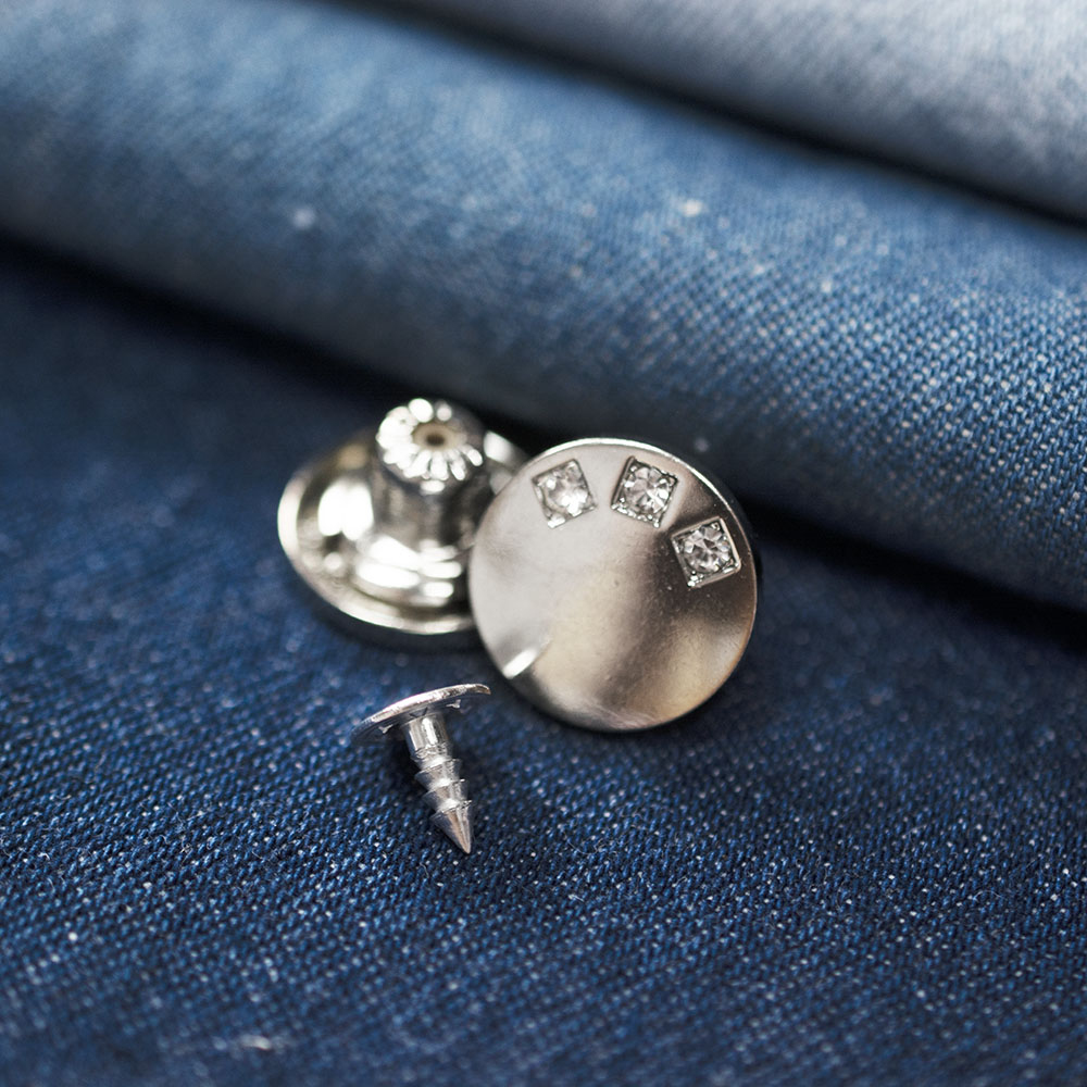 Guzik metalowy w kształcie koła o średnicy 1,7 cm.