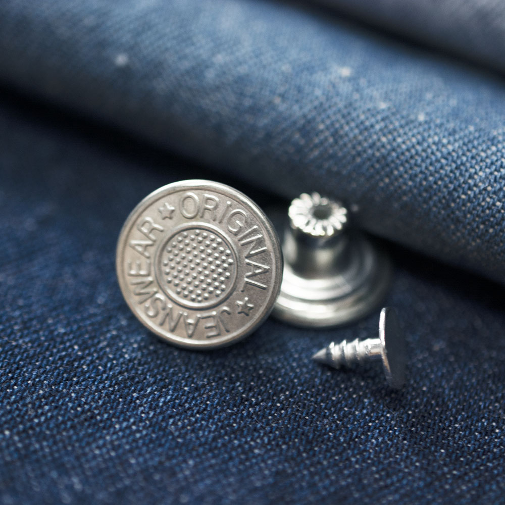 Guzik metalowy w kształcie koła o średnicy 1,6 cm.