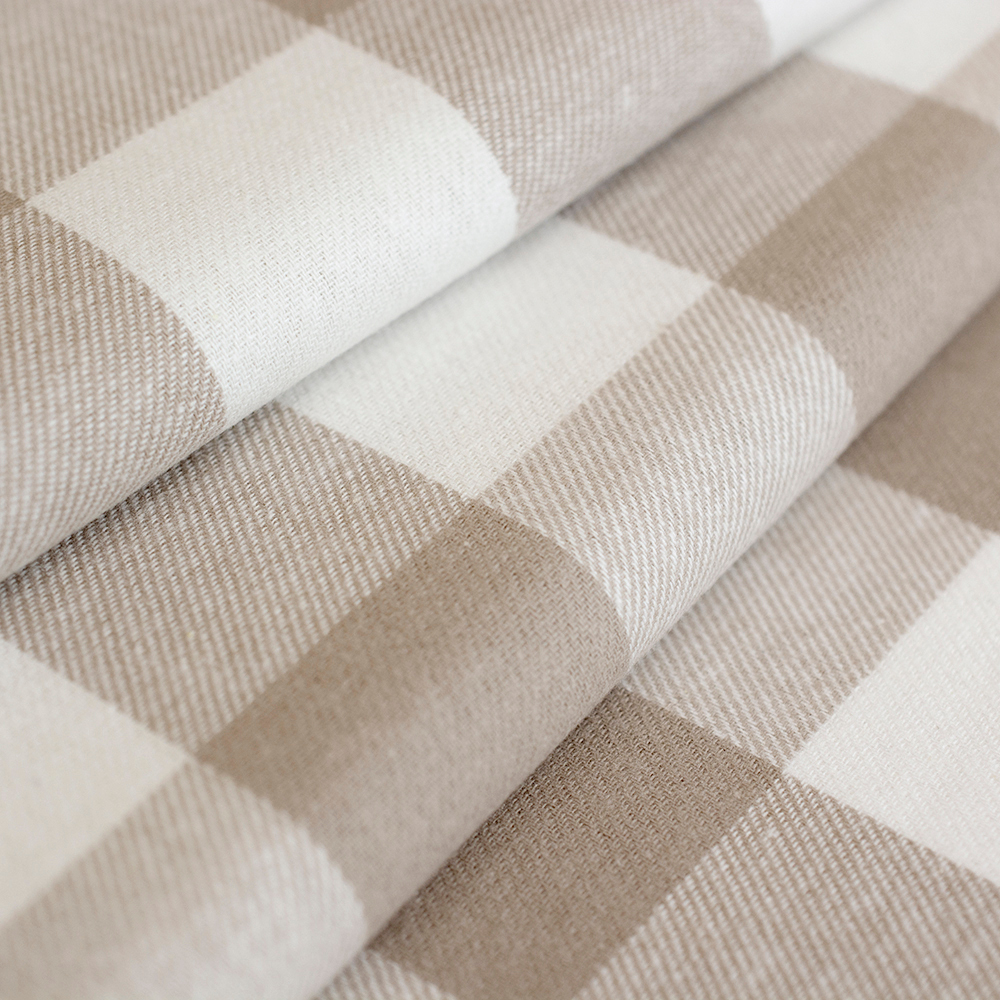 Miękka flanela wykonana z połączenia włókien bawełnianych i syntetycznych, w modnym wzorze kraty.