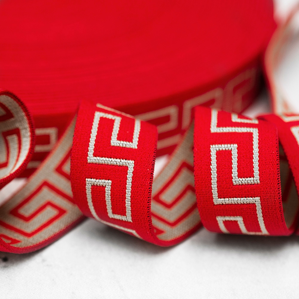 Ozdobna gumowa taśma w kolorze czerwonym, ozdobiona dodatkowo modnym wzorem w stylu greckim.