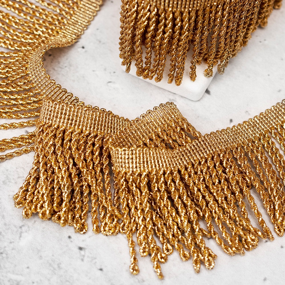 Ozdobne frędzle wykonane z metalicznej nici w kolorze złotym.