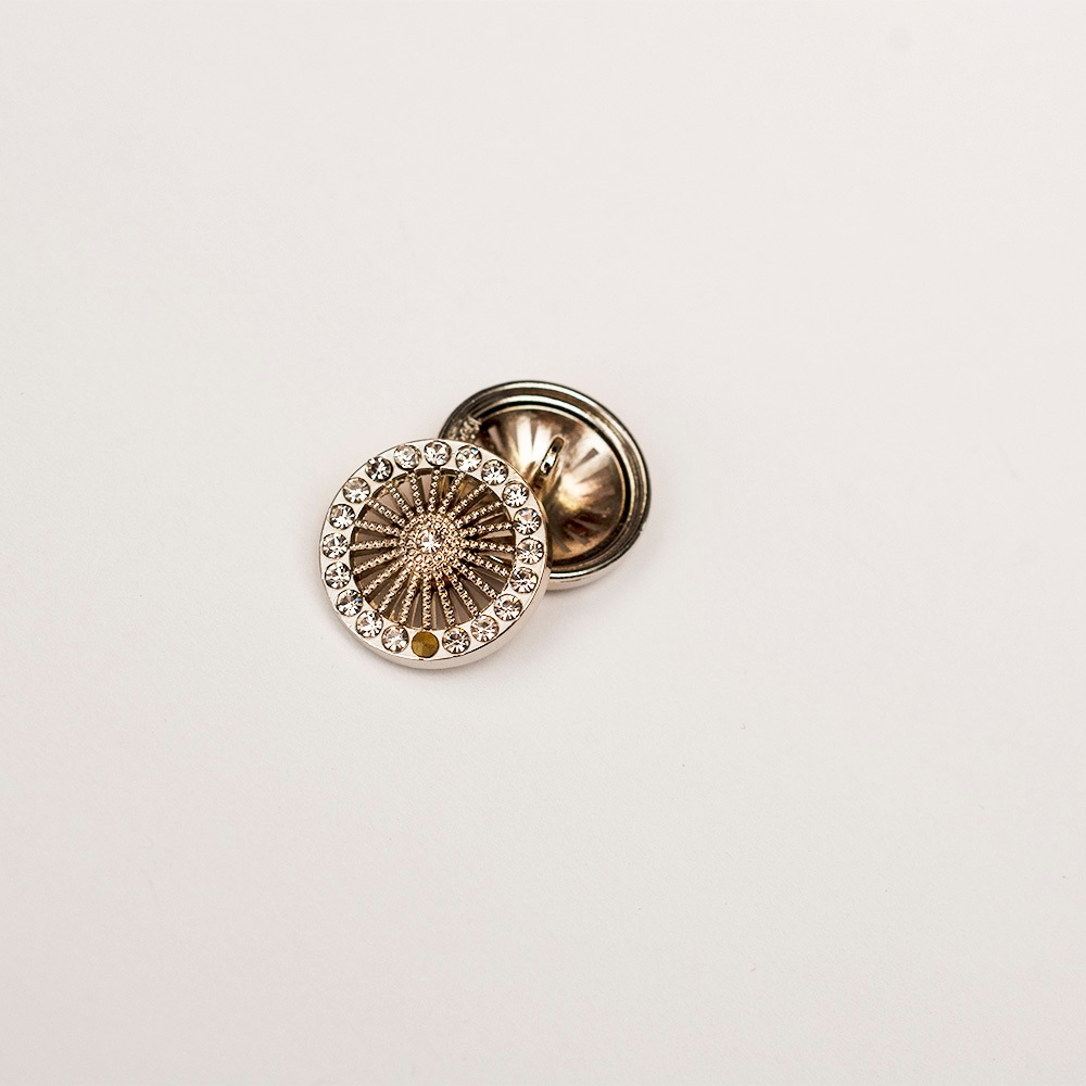 Guzik z masy perłowej w kształcie koła o średnicy 1,5 cm.