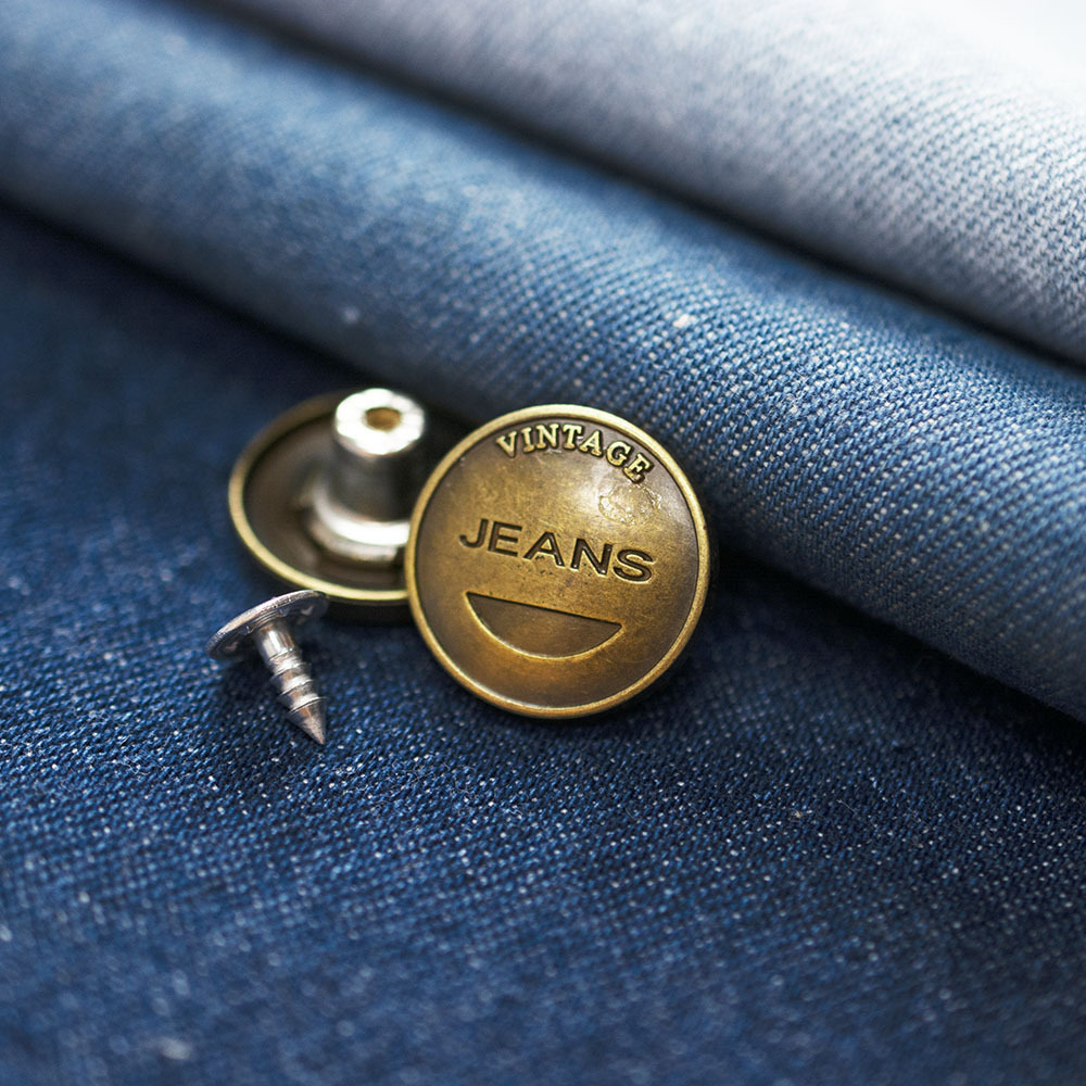 Guzik metalowy w kształcie koła o średnicy 2 cm.