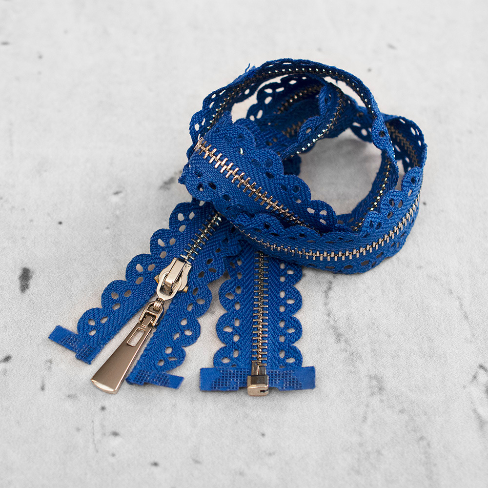 Zamek plastikowy typu kostka z eleganckimi, srebrnymi ząbkami.