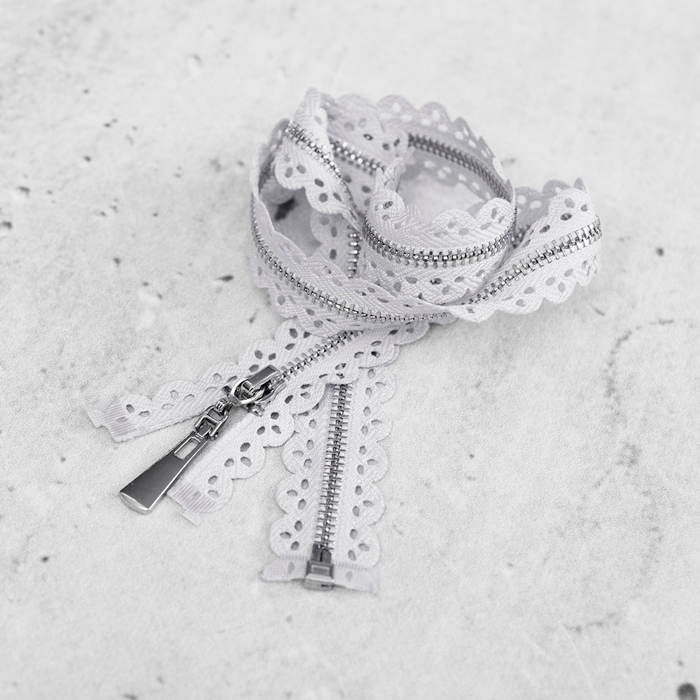 Zamek plastikowy typu kostka z eleganckimi, srebrnymi ząbkami.