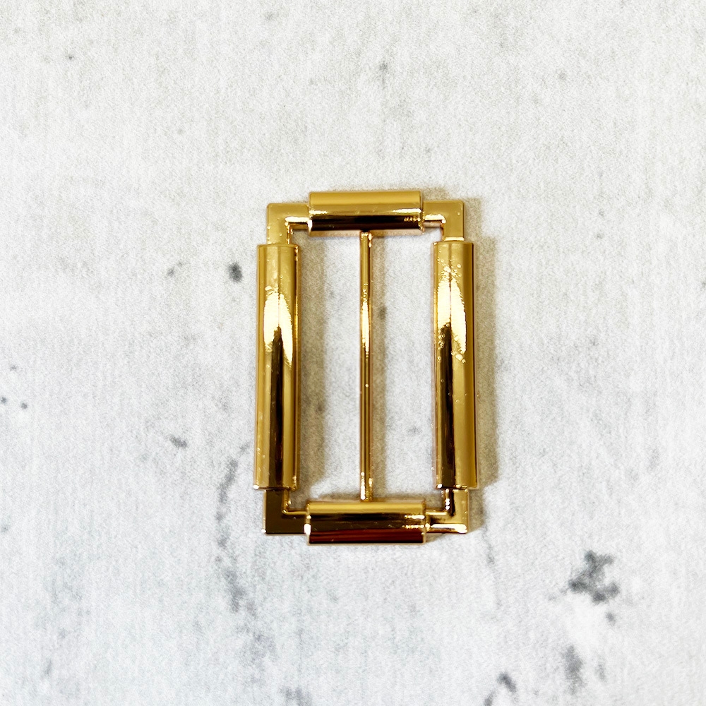 Metalowa klamerka do paska w kolorze złotym.