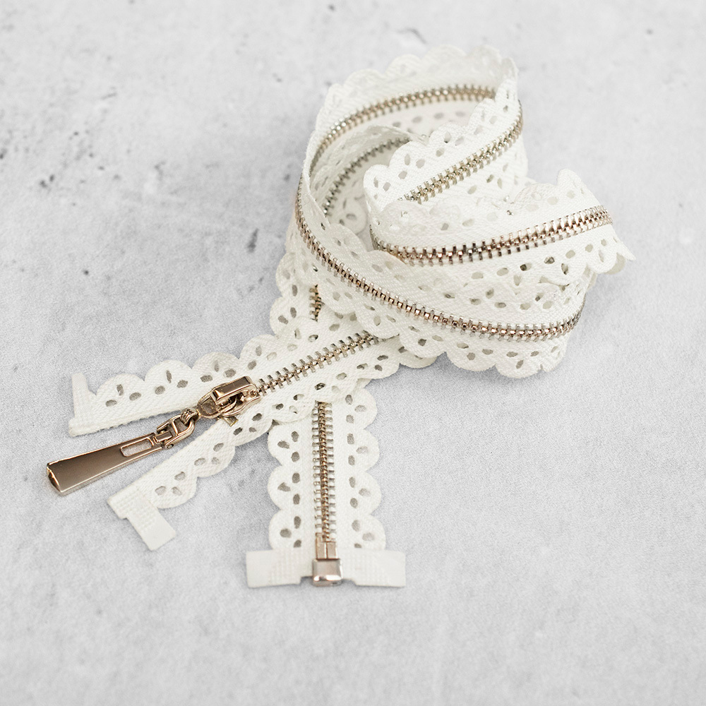 Zamek plastikowy typu kostka z eleganckimi, srebrnymi ząbkami.