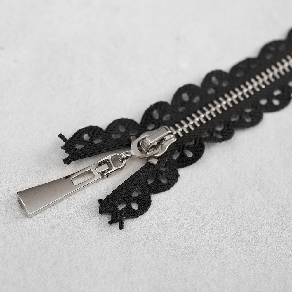 Zamek metalowy&nbsp;z eleganckimi, srebrnymi ząbkami.