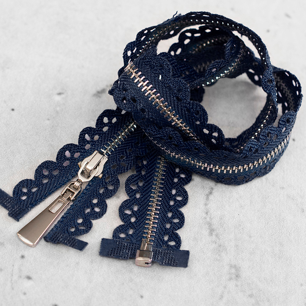 Zamek plastikowy typu kostka z eleganckimi, srebrnymi ząbkami.