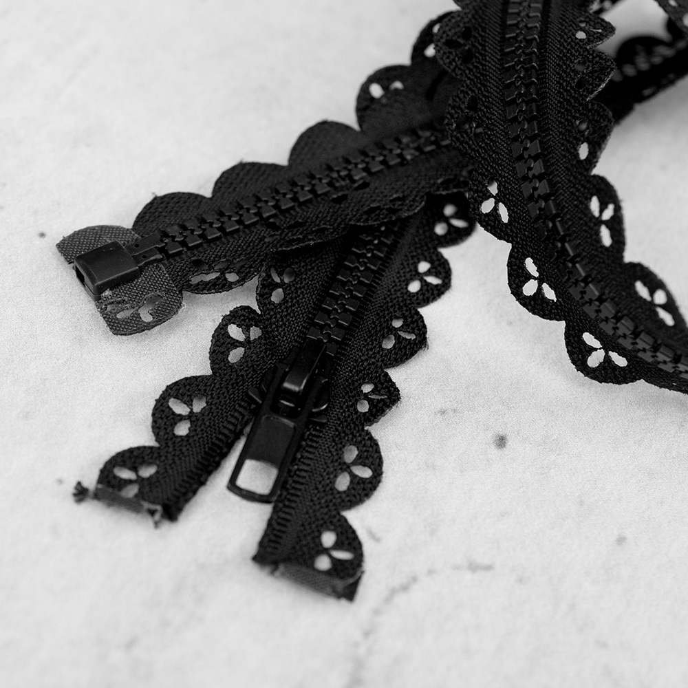 Zamek plastikowy typu kostka z eleganckimi, czarnymi ząbkami.