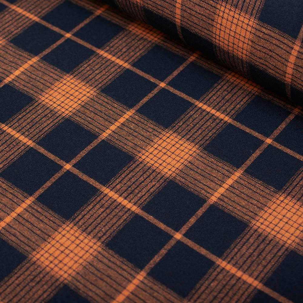 Miękka flanela wykonana z połączenia włókien bawełnianych i syntetycznych, w modnym wzorze kraty.