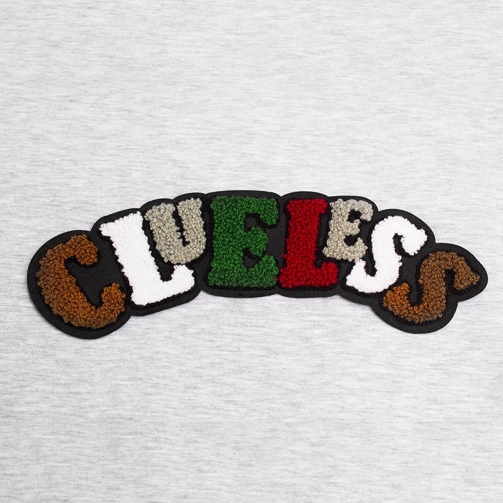 Pluszowa aplikacja na filcu z napisem Clueless, doskonała do ozdobienia bluzki, tuniki czy bluzy.