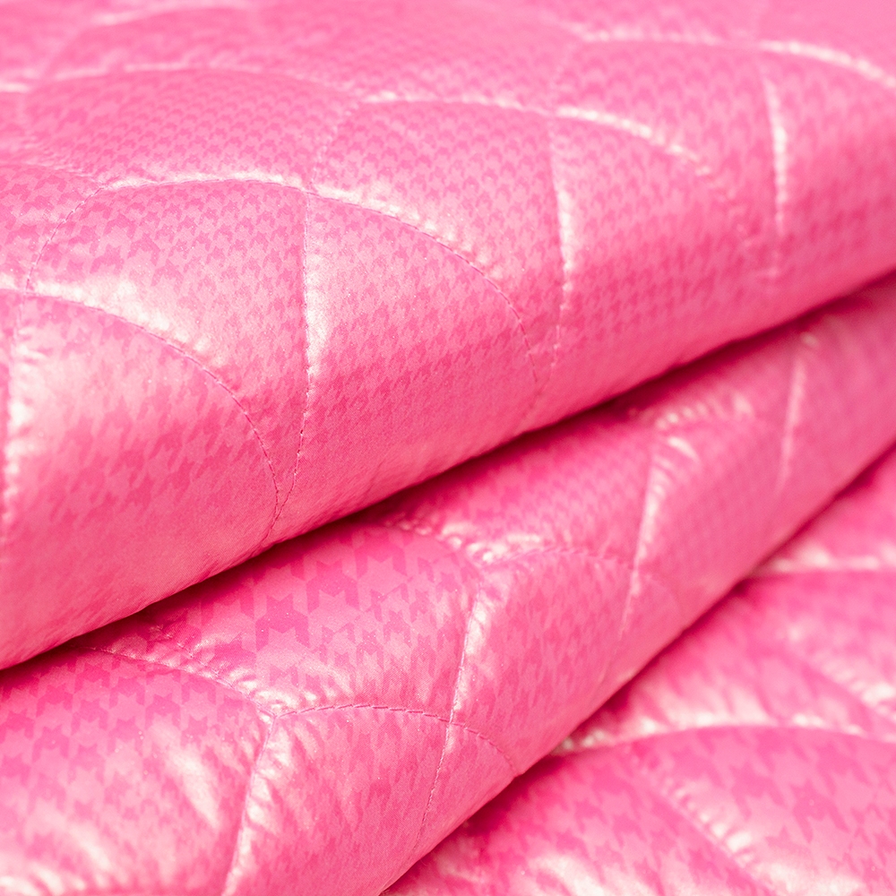 Tkanina pikowana wykonana z pastelowego ortalionu o bardzo ciekawym wzorze: perłowej pepitki.