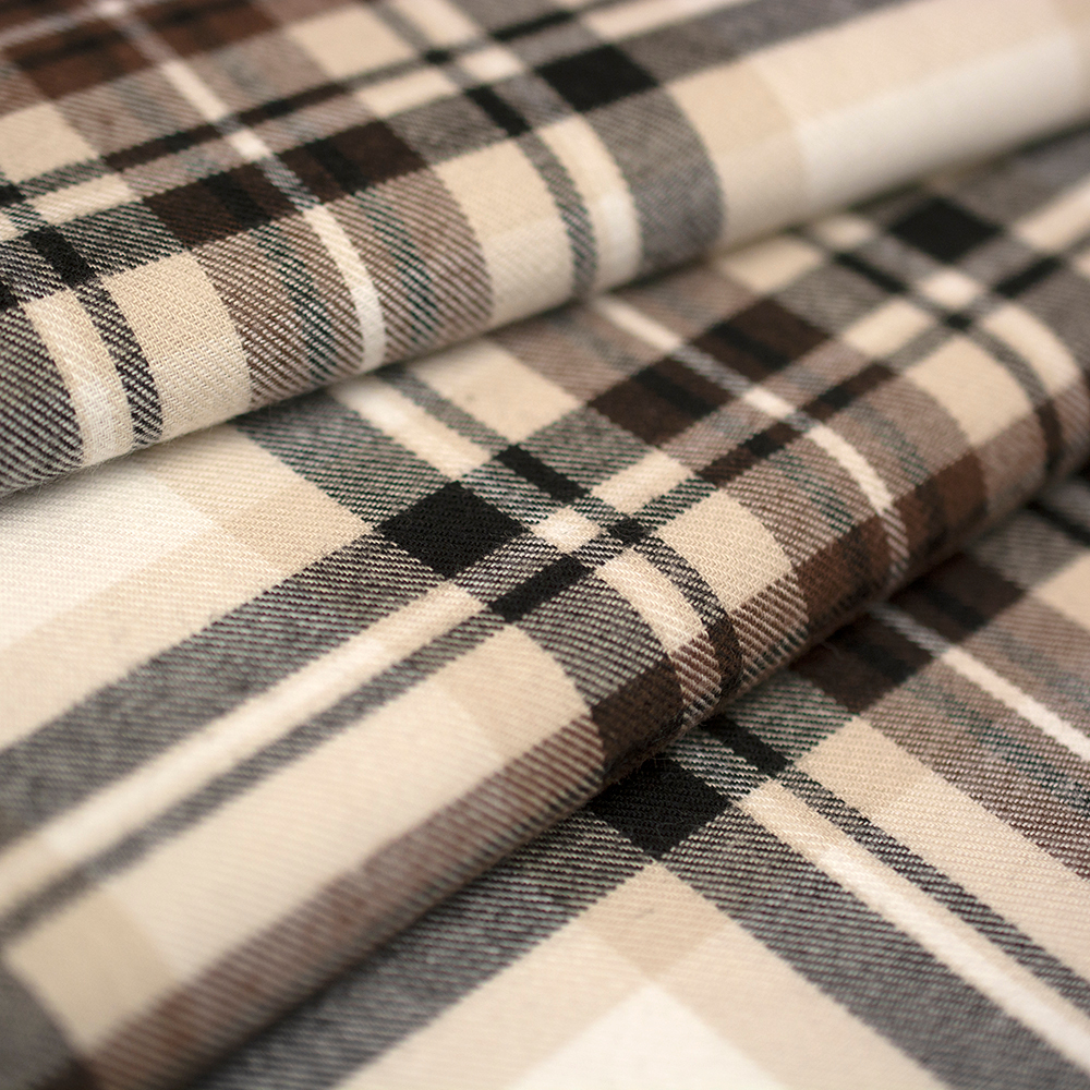 Miękka flanela wykonana z połączenia włókien bawełnianych i syntetycznych, w modnym wzorze kraty.