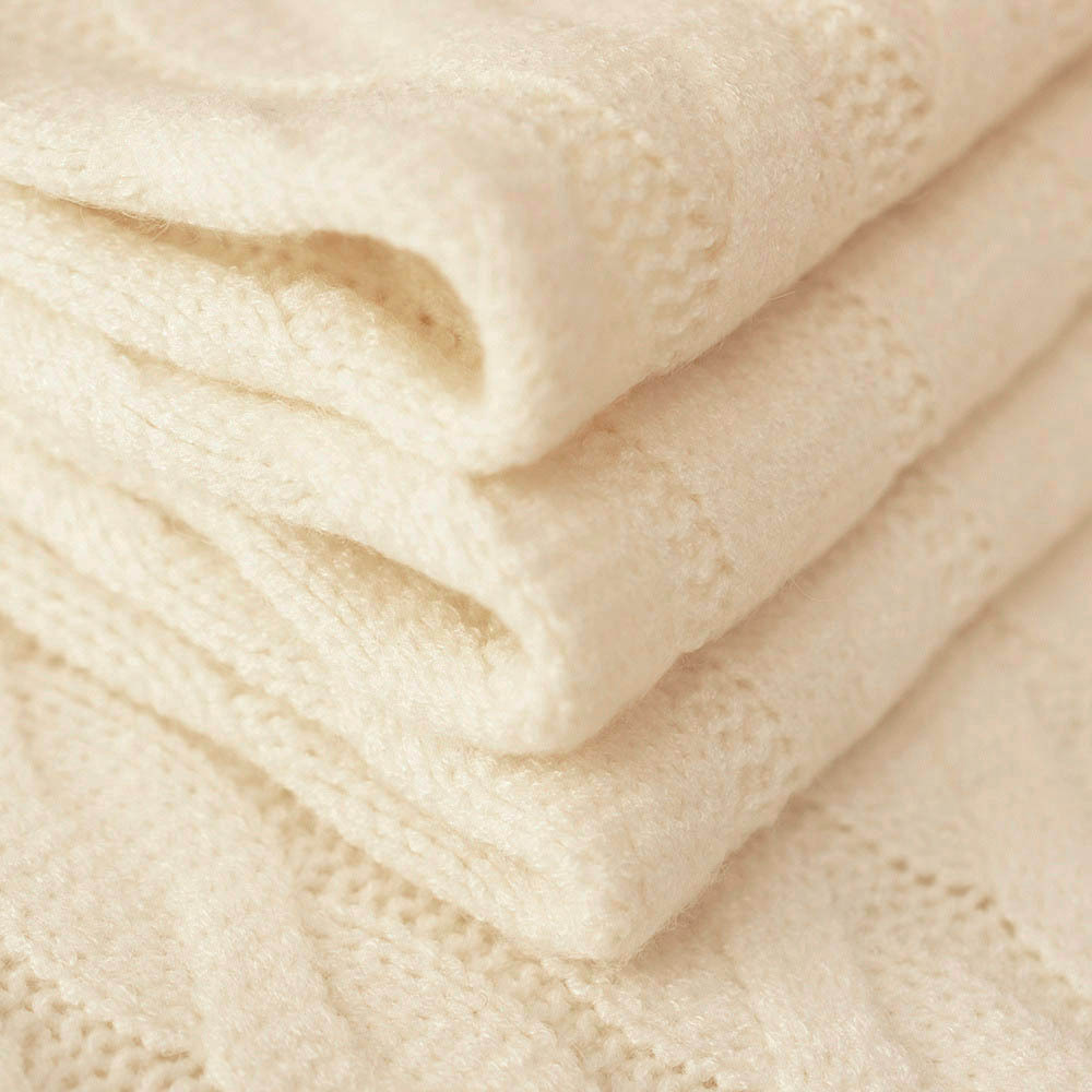 Swetrowa dzianina o efektownym splocie warkoczowym, wykonana z mieszanki włókien naturalnych i syntetycznych.