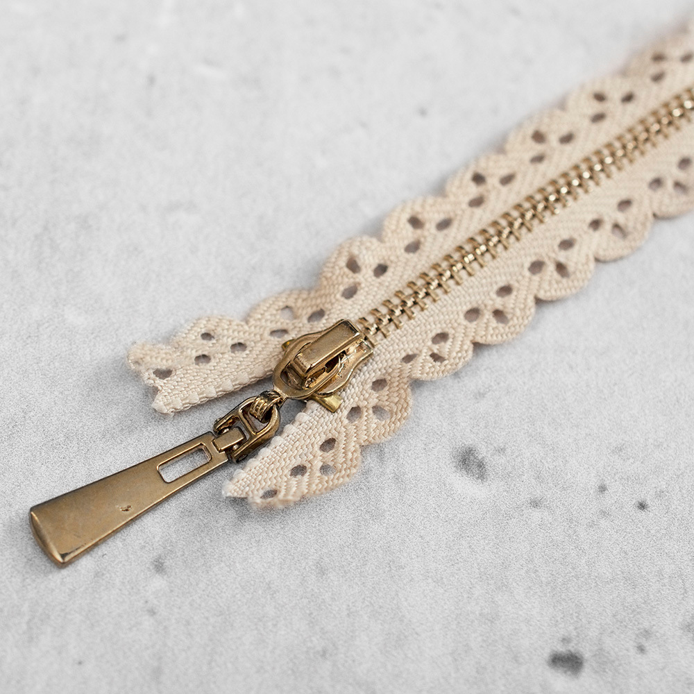 Zamek metalowy&nbsp;z eleganckimi, złotymi ząbkami.