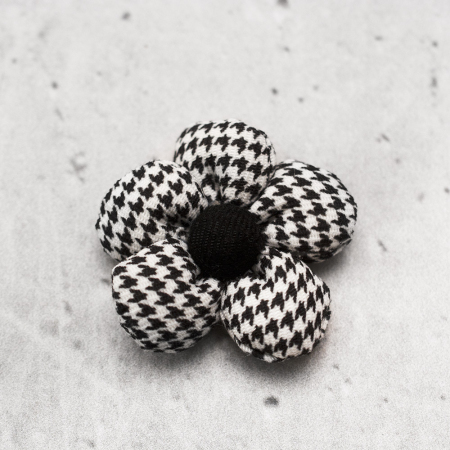 Oryginalna, trójwymiarowa apliacja w kształcie kwiata, wykonana z tkaniny z motywem pepitki.