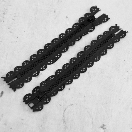 Zamek plastikowy typu kostka z eleganckimi, czarnymi ząbkami.