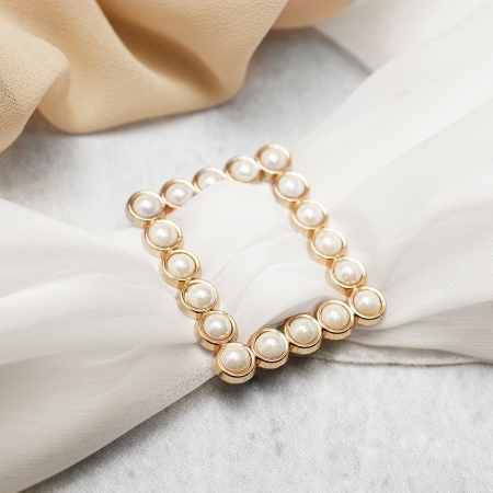 Ozdobna klamra pozłacana w kształcie prostokątna, ozdobiona dodatkowo perłami.