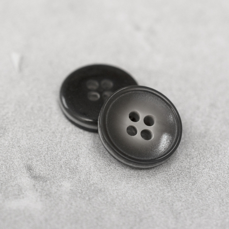 Plastikowy guzik przyszywany na cztery dziurki, o średnicy 1,5 cm.
