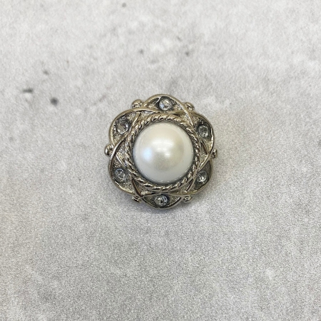 Plastikowy guzik na stopce w kolorze srebrnym, ozdobiony perłą i cyrkoniami.