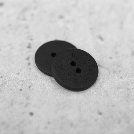 Plastikowy guzik przyszywany na dwie dziurki, o średnicy 2 cm.