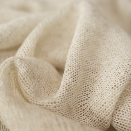 Cienka dzianina swetrowa w naturalnym kolorzeprzypominającym len.