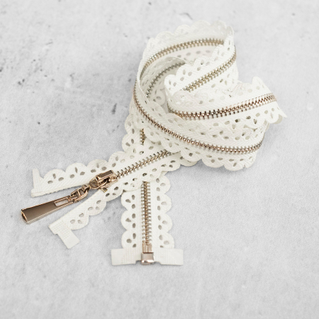 Zamek plastikowy typu kostka z eleganckimi, srebrnymi ząbkami.