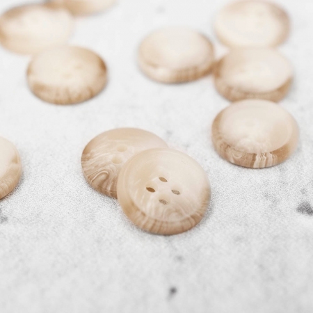 Plastikowy guzik o średnicy 1,5 cm, przyszywany na dwie dziurki.