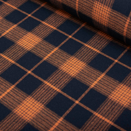 Miękka flanela wykonana z połączenia włókien bawełnianych i syntetycznych, w modnym wzorze kraty.