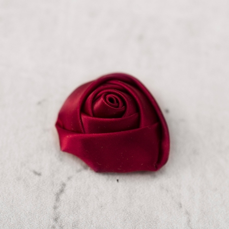 Dekoracyjna róża wykonana z satyny w jednolitym kolorze.
