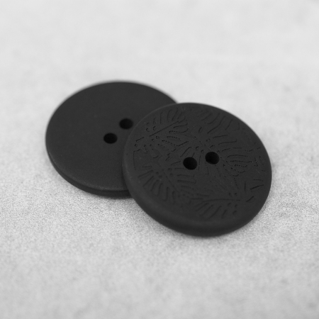 Plastikowy guzik przyszywany na dwie dziurki, o średnicy 2,6 cm.