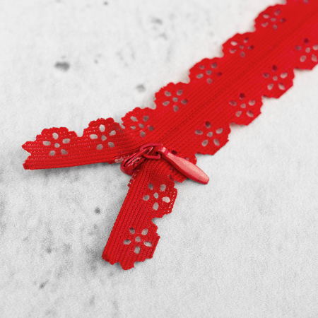 Zamek kryty z delikatną taśmą koronkową, wyposażony w subtelny&nbsp;suwak.