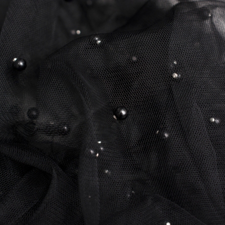Delikatna tkanina o ażurowym splocie i jednolitym, czarnym zabarwieniu.