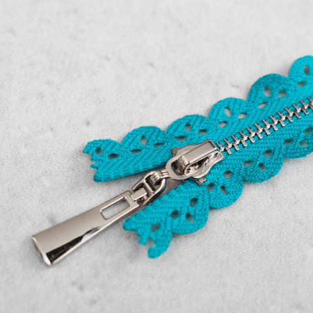 Zamek metalowy&nbsp;z eleganckimi, srebrnymi ząbkami.