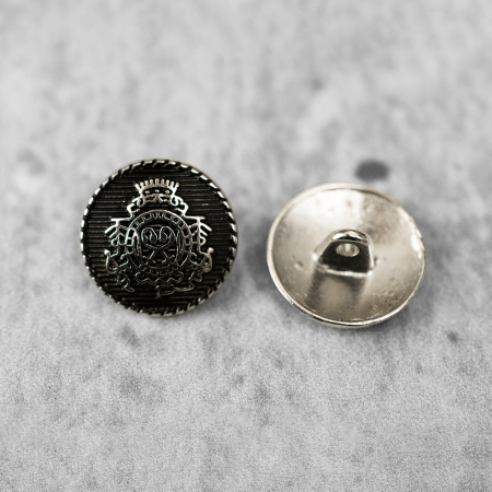 Guzik metalowy na stopce, o średnicy 1,8 cm.