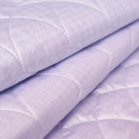 Tkanina pikowana wykonana z pastelowego ortalionu o bardzo ciekawym wzorze: perłowej pepitki.
