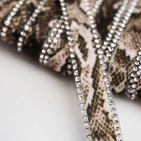 Ozdobna taśma termoaktywna ozdobiona modnym wzorem wężowej skóry oraz wykończona z obu stron kryształkami.