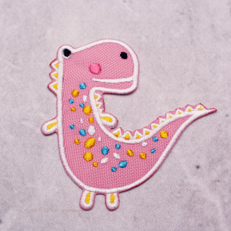 Aplikacja termoprzylepna SWEET DINO w kolorze jasno różowym o wymiarach: 8 cm x 8 cm.