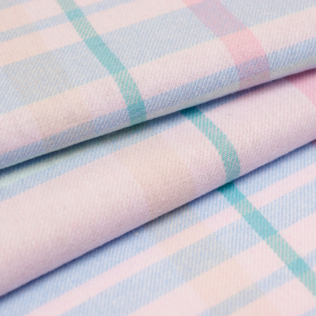 Miękka flanela wykonana z połączenia włókien bawełnianych i syntetycznych, w modnym wzorze kraty.