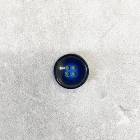 Plastikowy guzik z czterema dziurkami, w kolorze niebiesko-czarnym.
