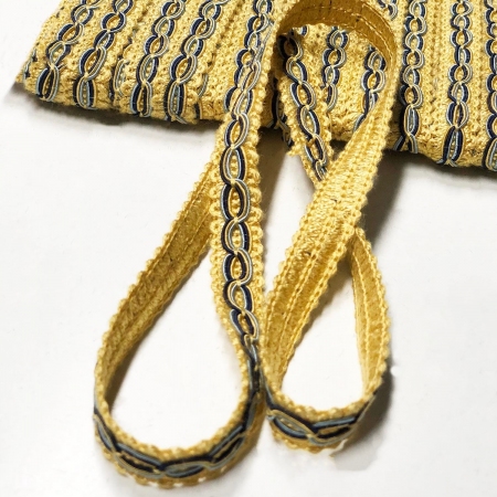 Ozdobna taśma w kolorze żółtego złota z oryginalnym, haftowanym wzorem w postaci ringów.