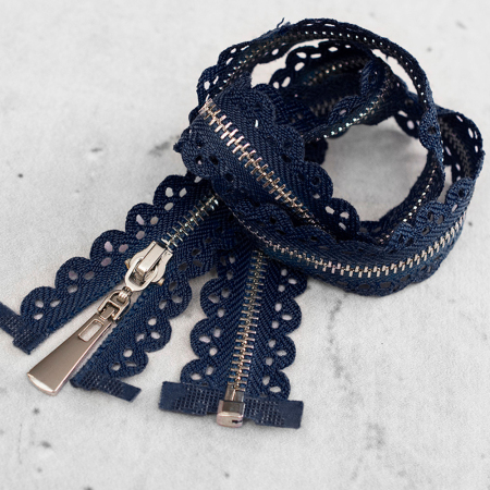 Zamek plastikowy typu kostka z eleganckimi, srebrnymi ząbkami.