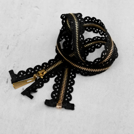 Zamek plastikowy typu kostka z eleganckimi, złotymi ząbkami.